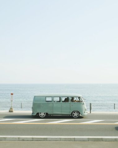 van parked beside the road near handrail and ocean